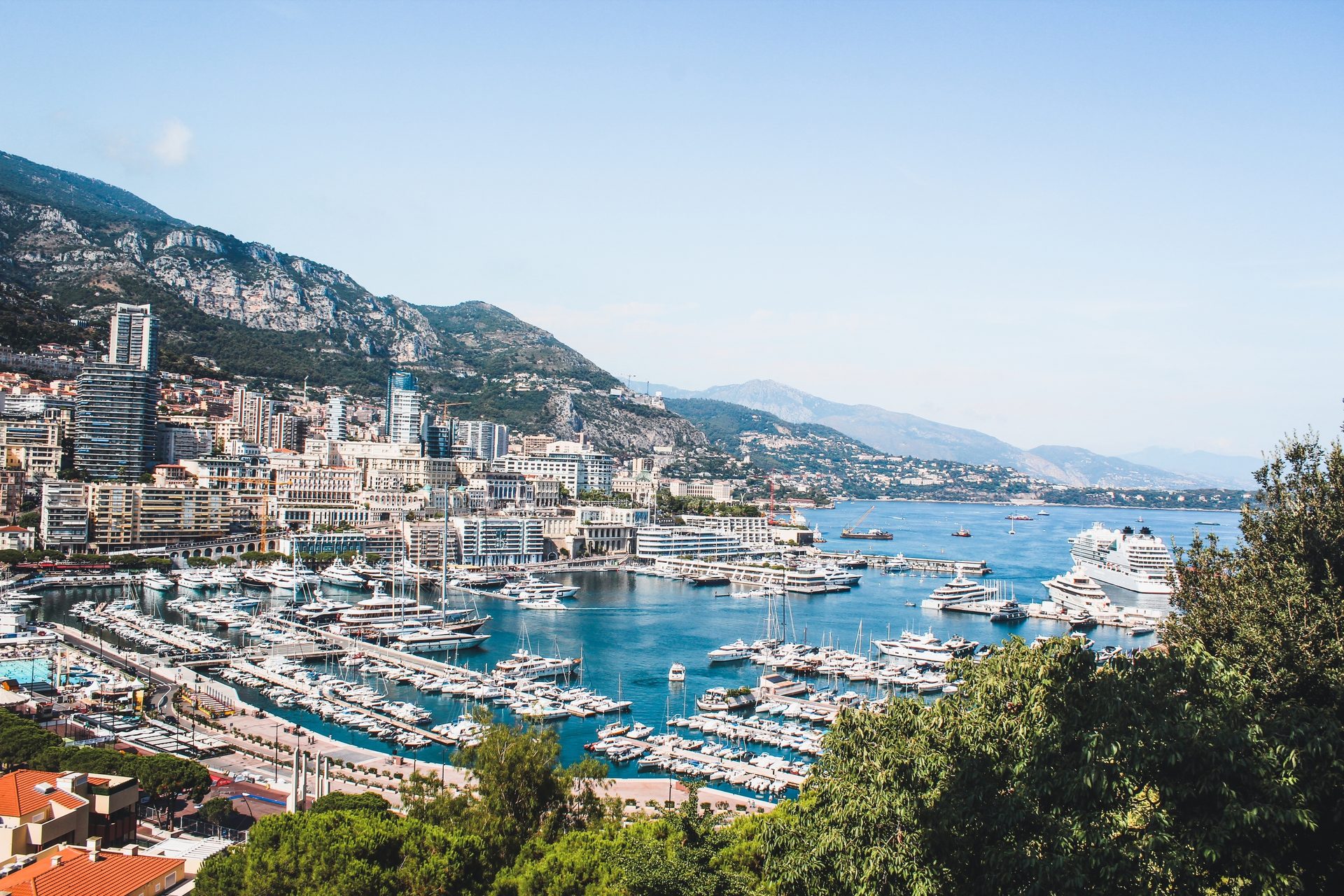 Coastal and oceanic landforms, Water resources, Sky, Boat, Watercraft, Azure, Building, Mountain, Tree