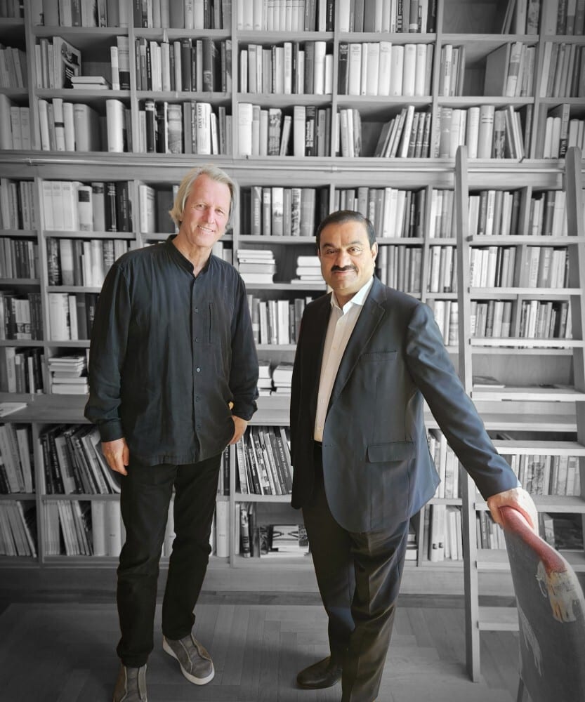 Suit trousers, Dress shirt, Bookcase, Smile, Shelf, Human, Book, Gesture, Publication, Shelving