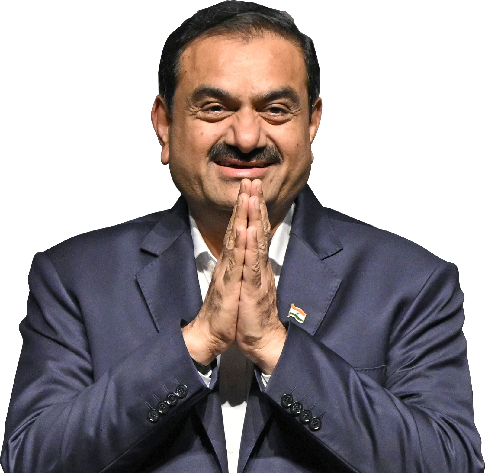 Gautam Adani smiling, wearing a suit, with hands in namaste gesture and an Indian flag pin.
