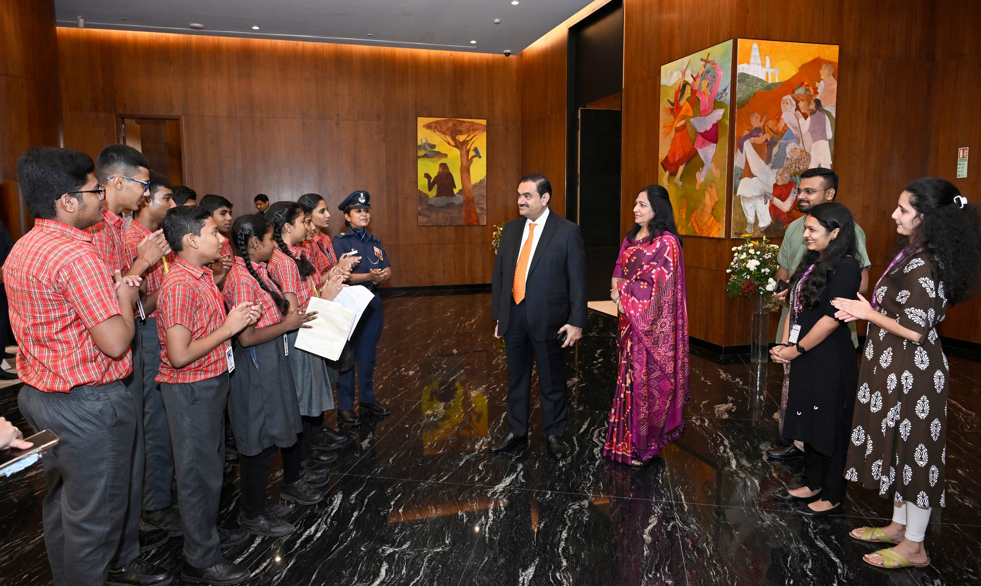 Gautam and Priti Adani with students and staff indoors.
