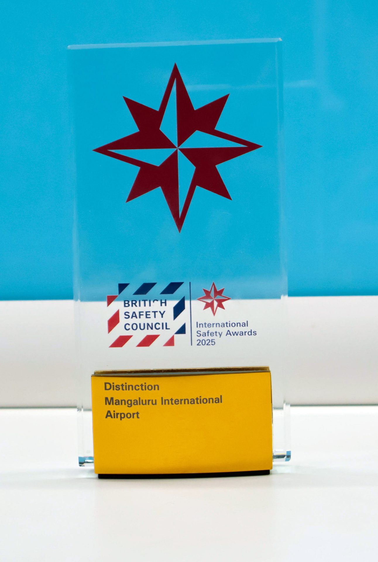 A clear acrylic trophy for British Safety Council Int. Safety Awards 2025, Distinction for Mangaluru Airport.