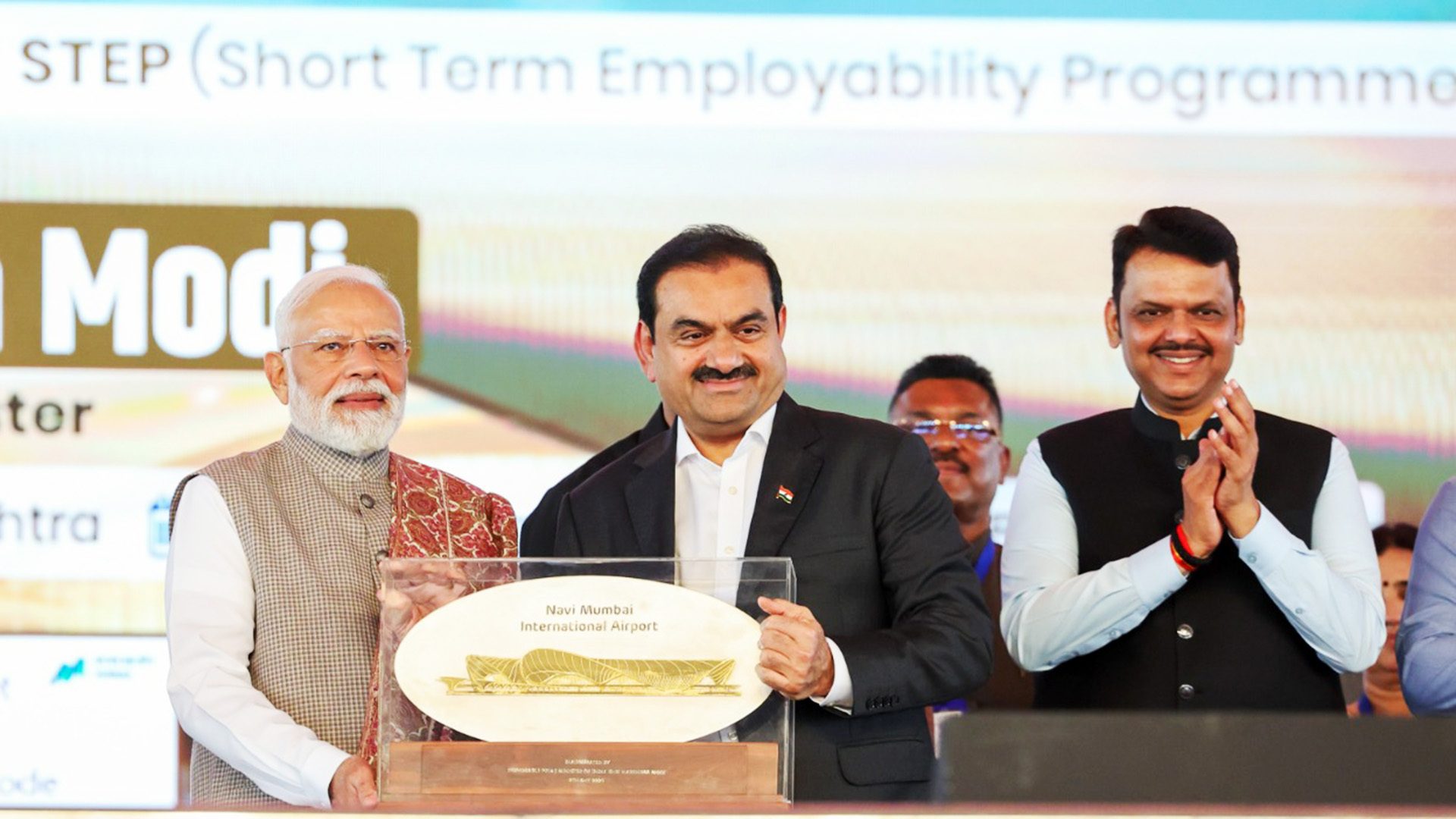 PM Modi, Gautam Adani, and Devendra Fadnavis with Navi Mumbai International Airport plaque.