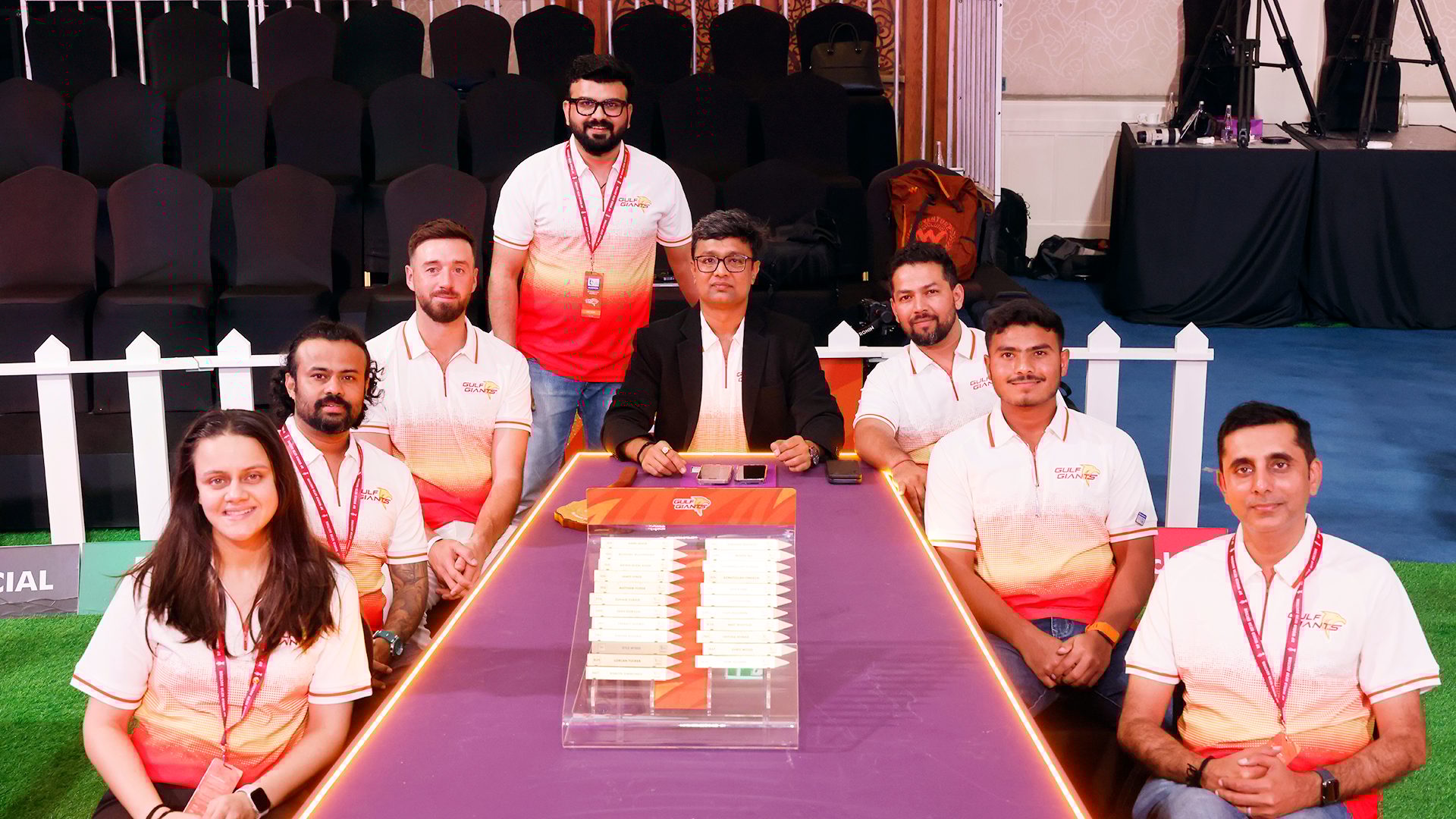 Nine Gulf Giants team members at a draft table.
