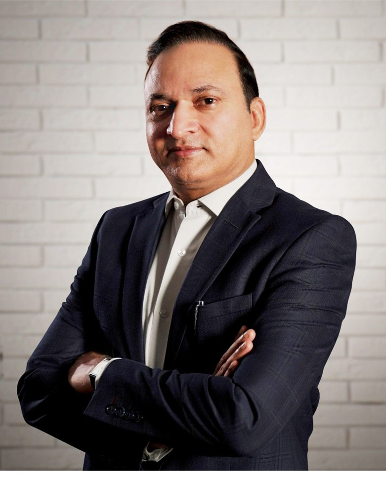 A professional portrait of a man in a dark suit with a white shirt, arms crossed, looking at the camera.