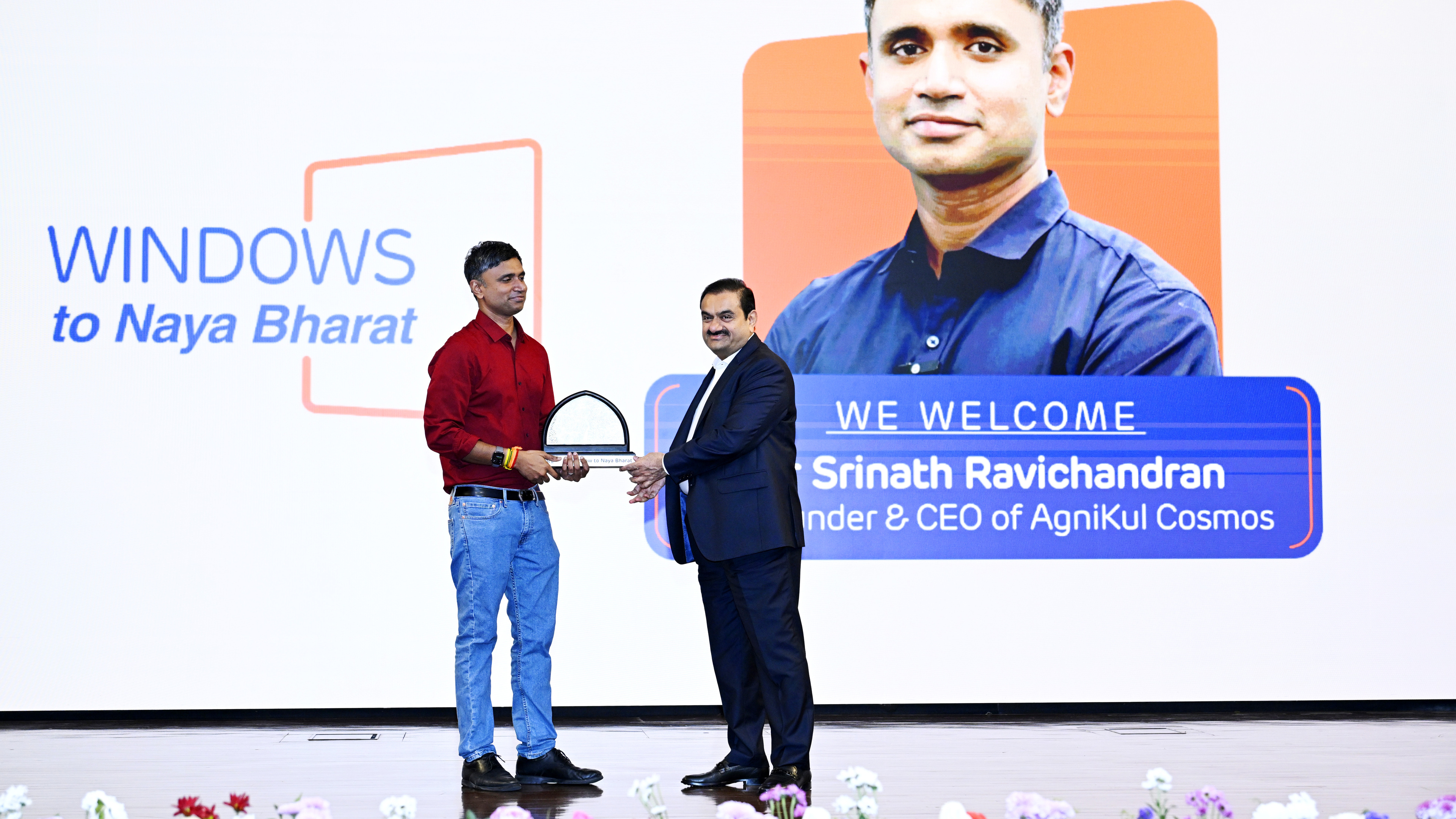 Gautam Adani presents award to AgniKul Cosmos CEO Srinath Ravichandran on stage.