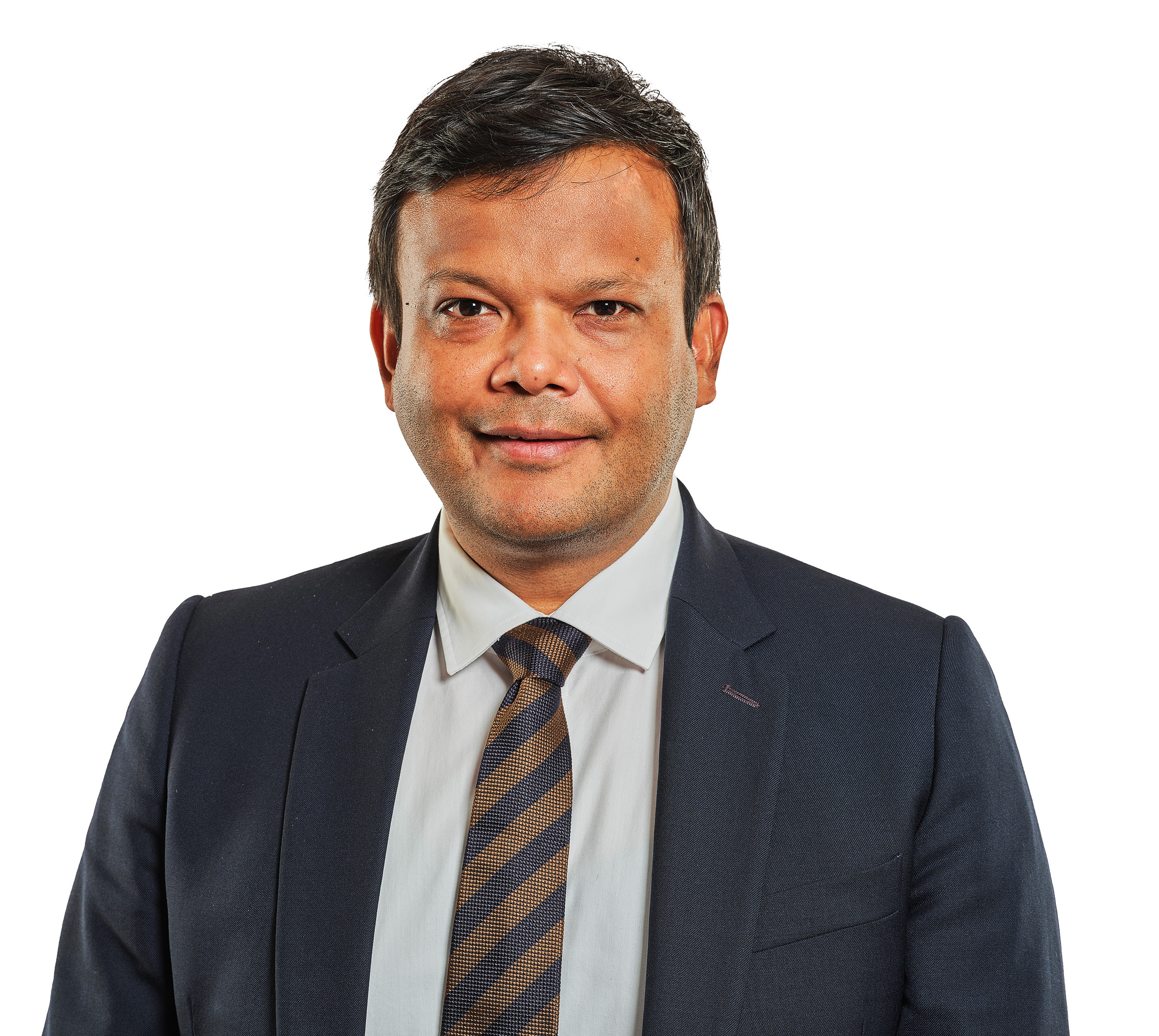 Smiling man in dark suit and striped tie against a white background.