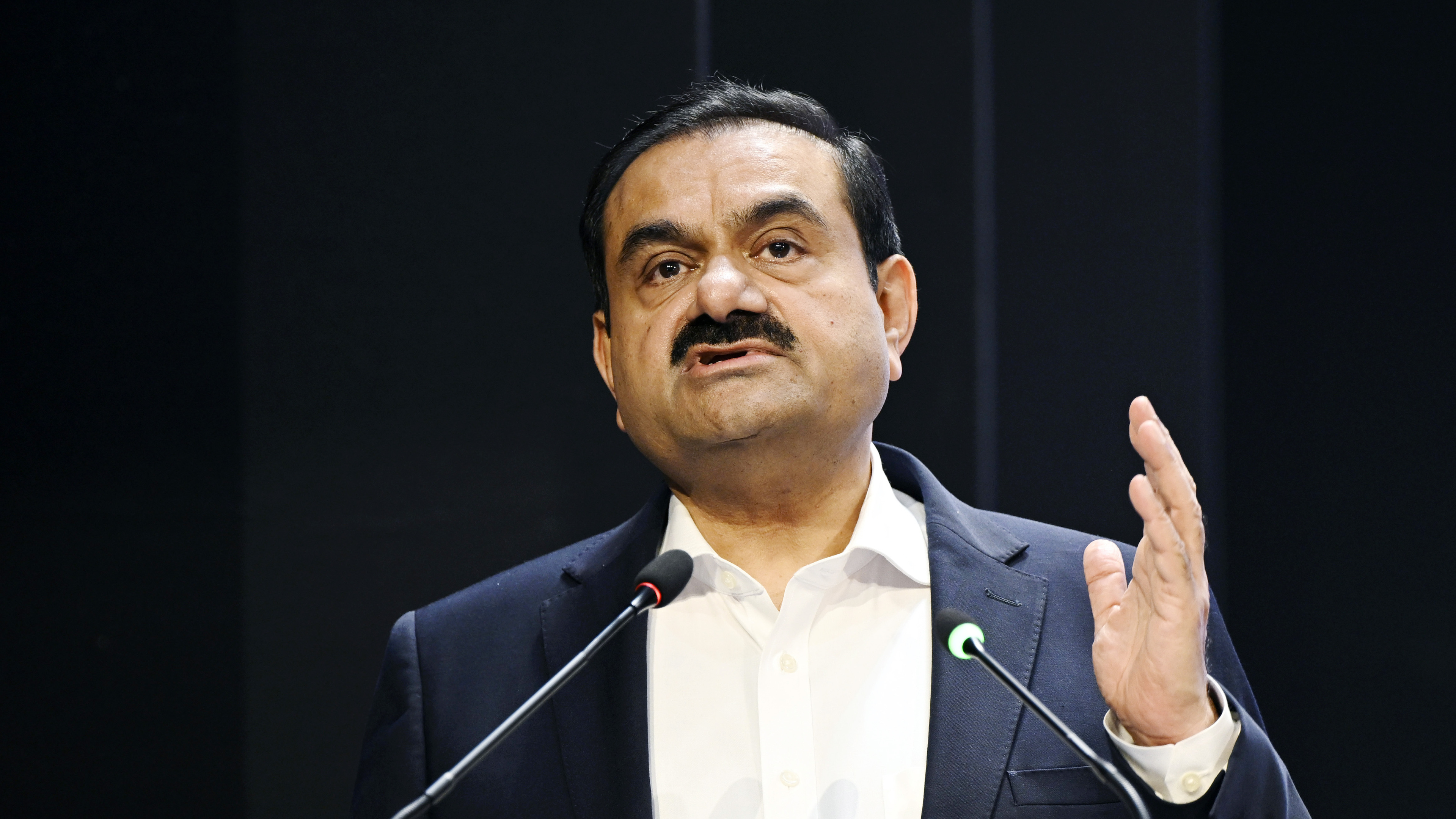 Gautam Adani speaking at microphones.