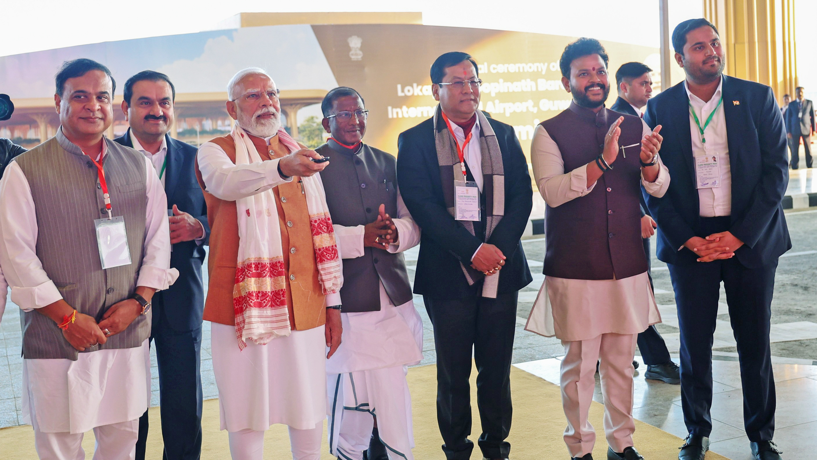 PM Modi points, with Himanta Biswa Sarma, Gautam Adani, and others at a ceremony.