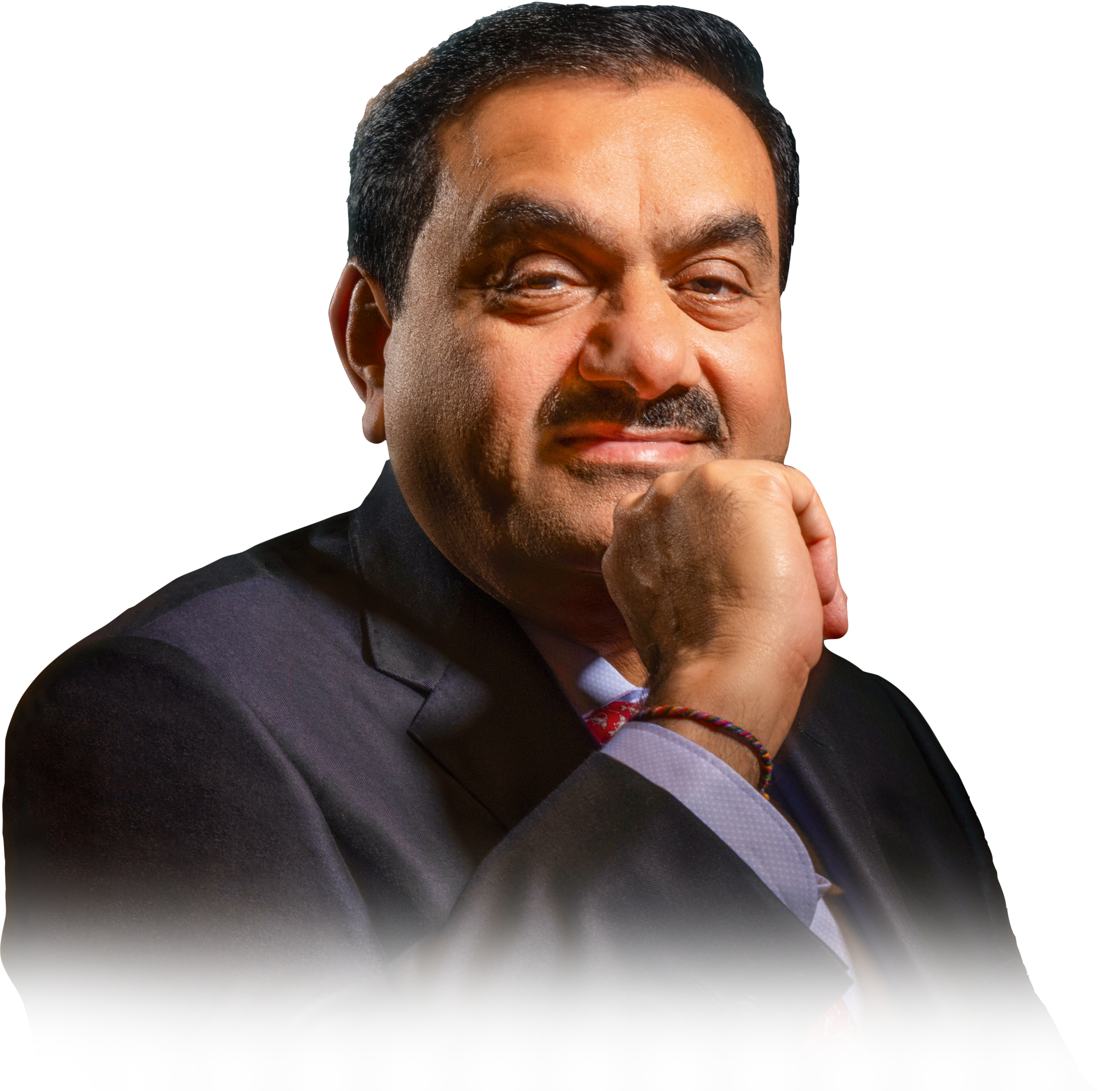 Close-up portrait of Indian businessman Gautam Adani in a suit, smiling with his hand on his chin.