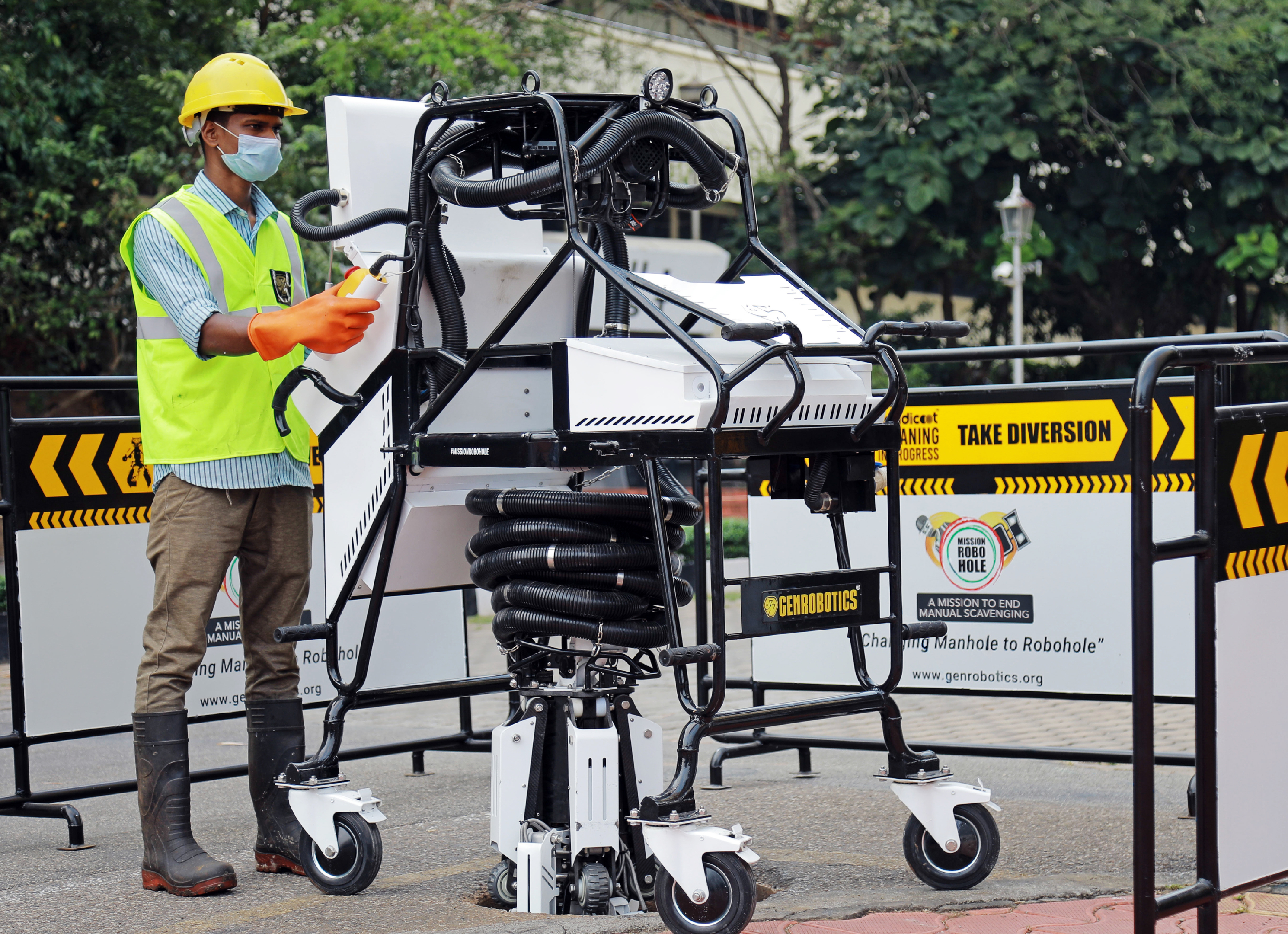 Man in safety gear operates Genrobotics Bandicoot robot for manhole cleaning, ending manual scavenging.