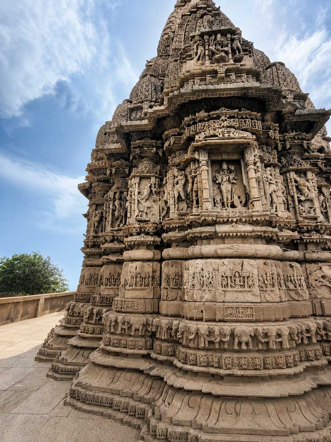 A low-angle view of an ancient Indian stone temple, showcasing its incredibly detailed sculptures and architecture.
