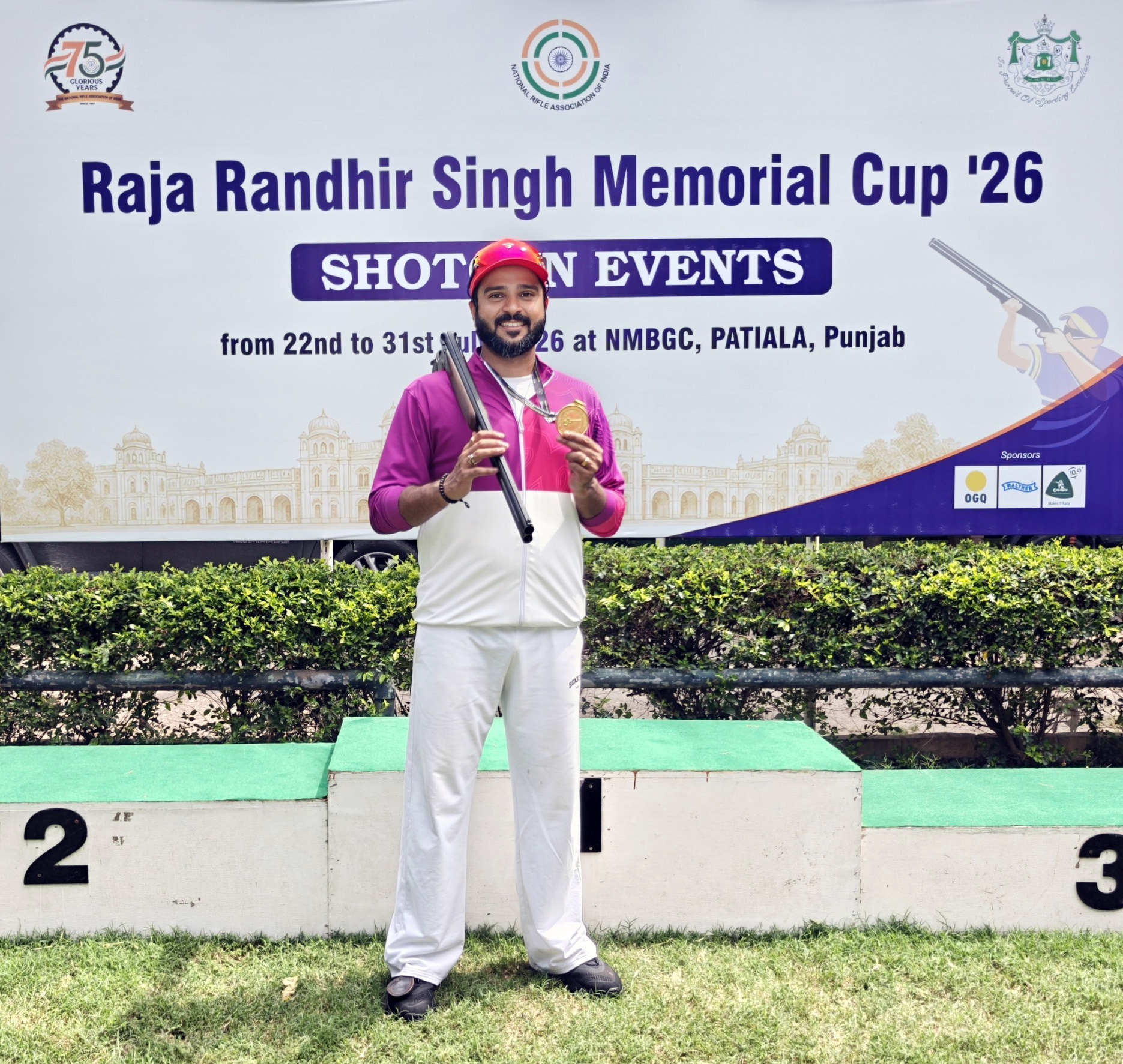 Male shooter with a gold medal and rifle on a podium at the Raja Randhir Singh Memorial Cup '26.