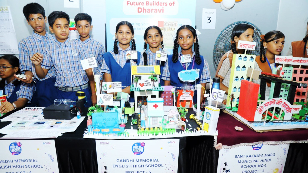 Indian students presenting urban development and sustainability projects at a school exhibition in Dharavi.
