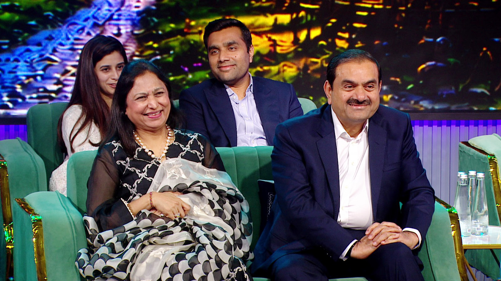 Gautam Adani with his wife Priti Adani, son Karan, and daughter-in-law Paridhi, all smiling.