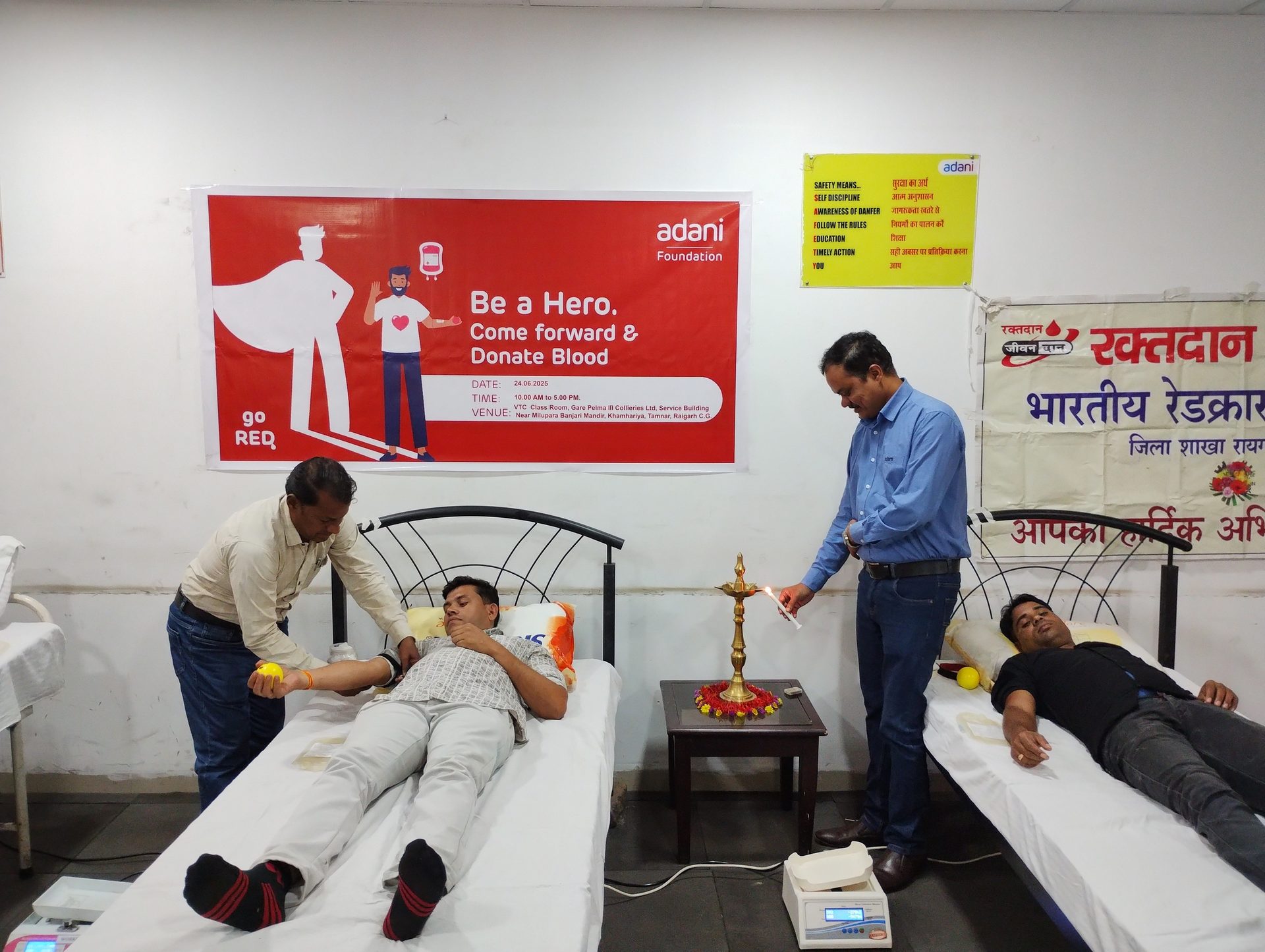 Blood donation camp organized by Adani Foundation & Indian Red Cross, with people donating blood.
