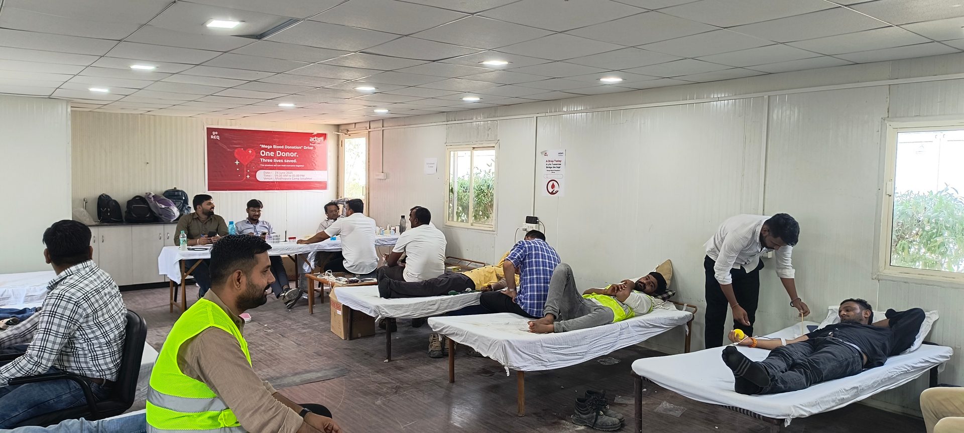 Men donating blood at an indoor blood donation drive.