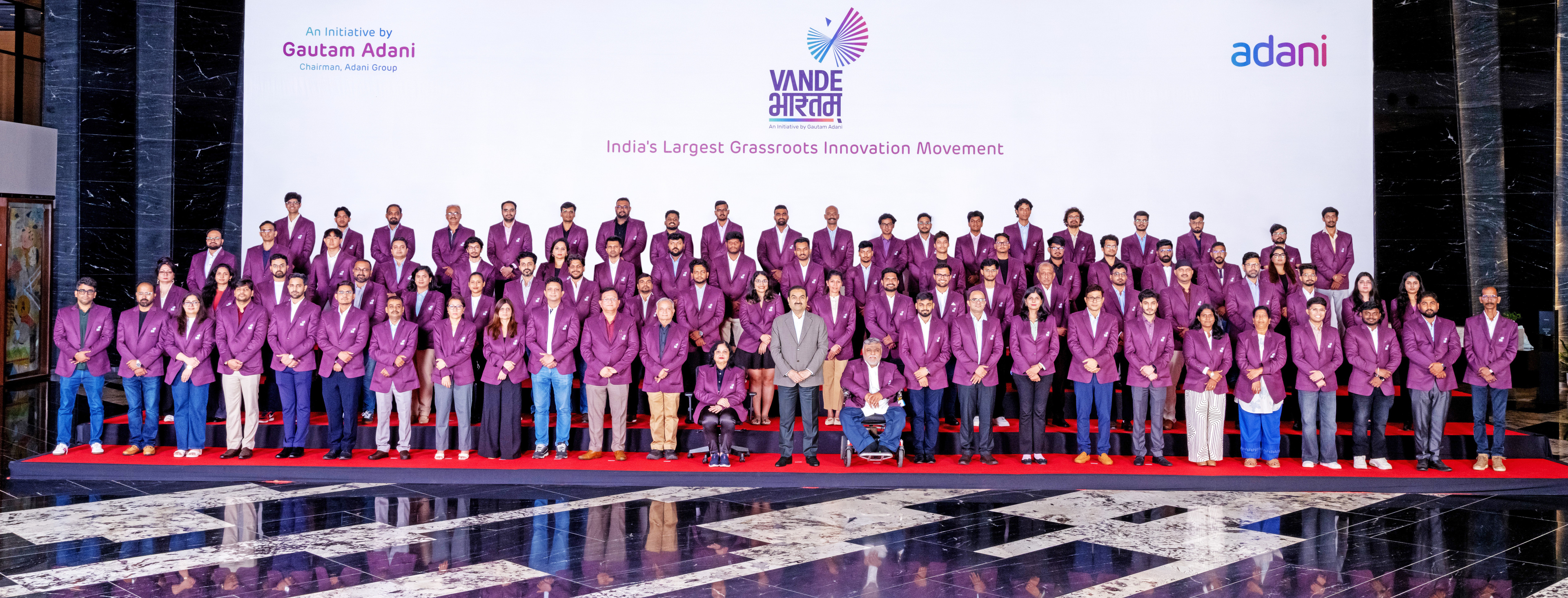 A large group photo of participants in purple jackets at the Vande Bharat Grassroots Innovation Movement event.