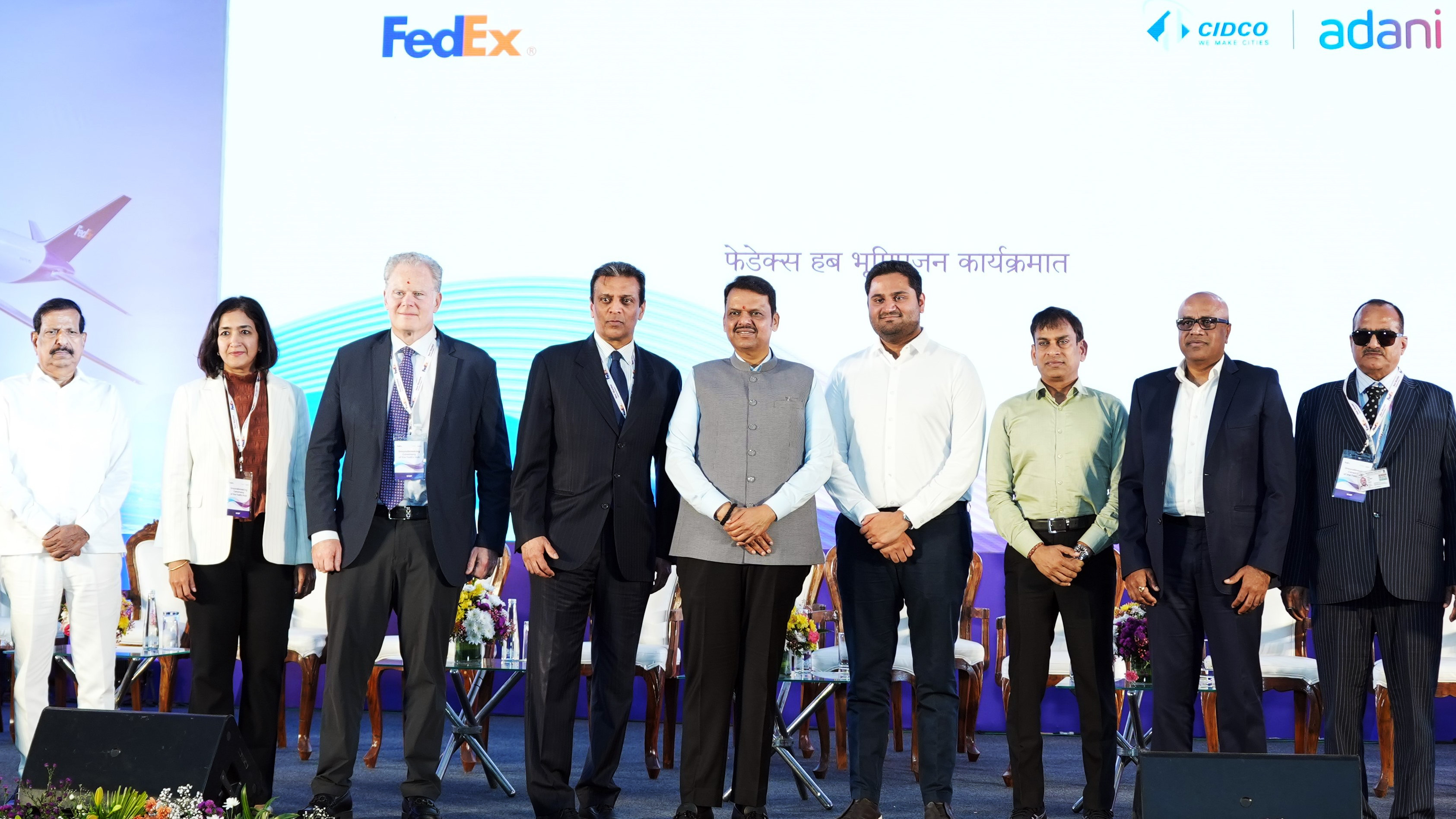 Executives from FedEx, CIDCO, and Adani group standing on a stage with company logos in the background.