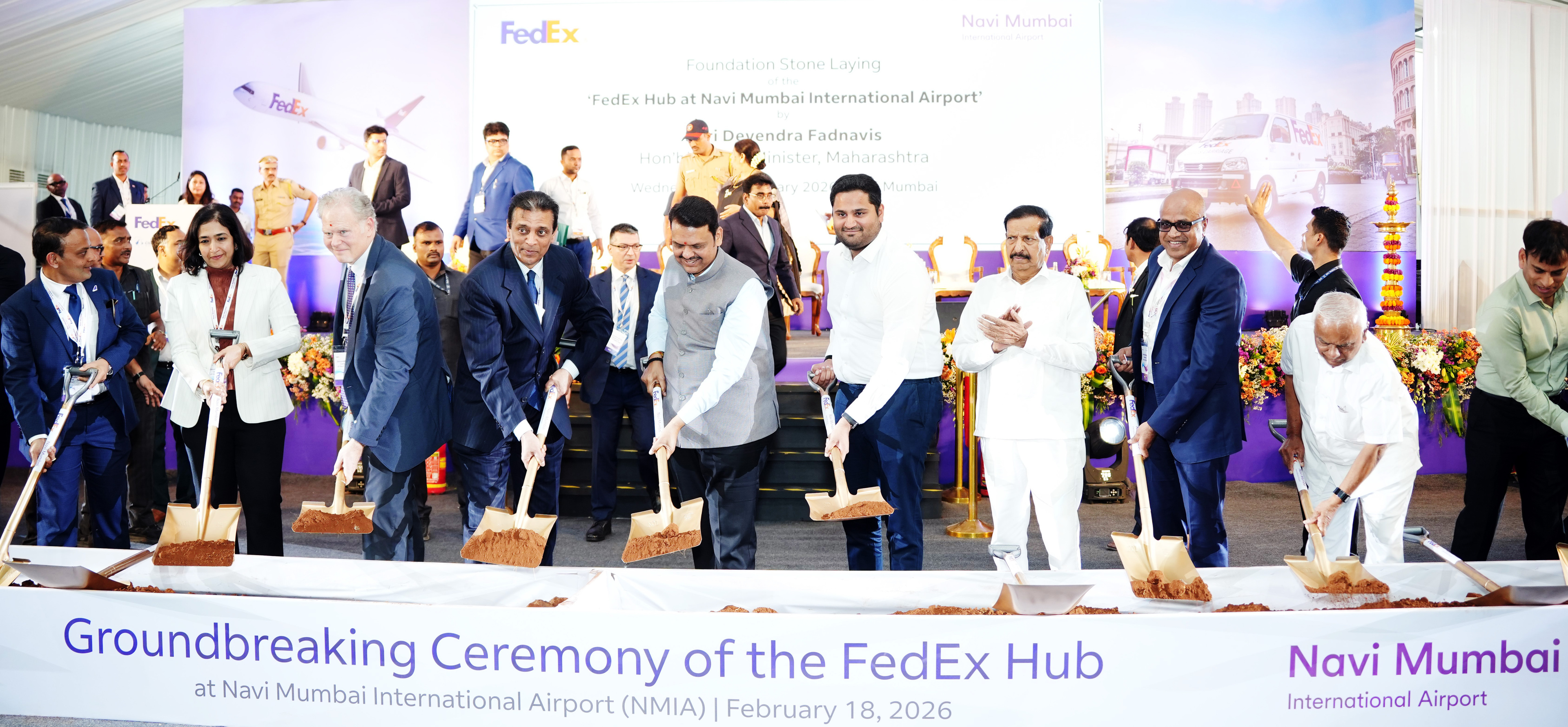 Officials and executives participate in the groundbreaking ceremony for the FedEx Hub at Navi Mumbai International Airport, shoveling soil.